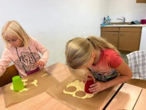 Kinder beim Ausstechen der Kekse.