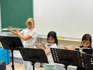 Kinder der Musik-Ag beim Querflöte spielen.