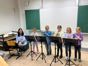 Kinder des Musikprojekts beim Blockflöte spielen.