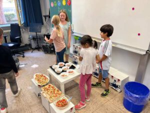 Die Kinder der Koch-AG in der Klasse vor der Tafel bei der Vorstellung der zubereiteten Bruschetta