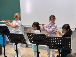 4 Kinder des Musikprojekts, die Querflöte spielen.